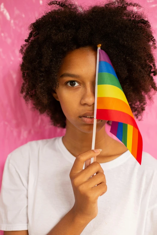 a beautiful woman holding a rainbow flag under her eye