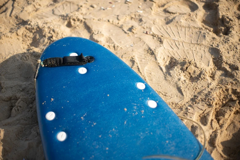 a blue surfboard lying on a sandy beach