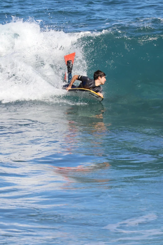 a man laying on his stomach while riding a surfboard in the water