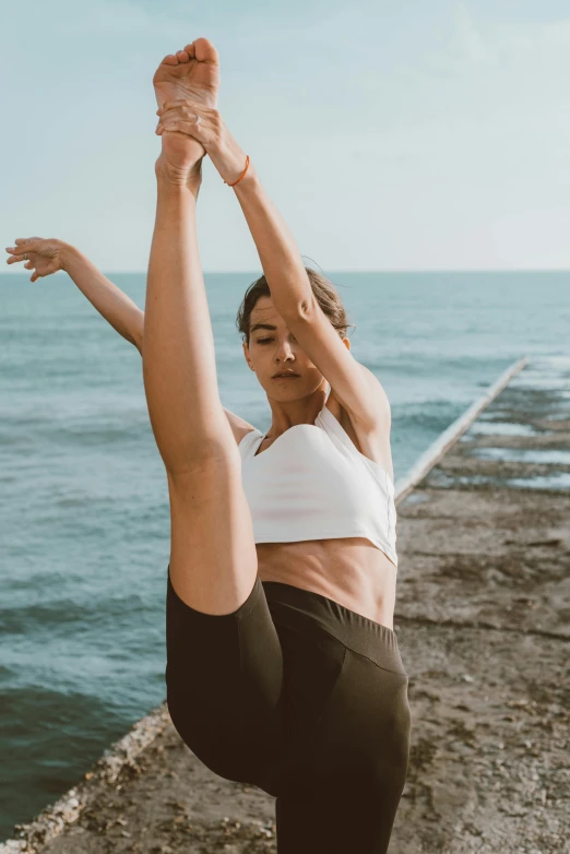 a woman in a yoga position in front of the ocean