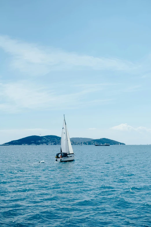 a sail boat that is out in the ocean