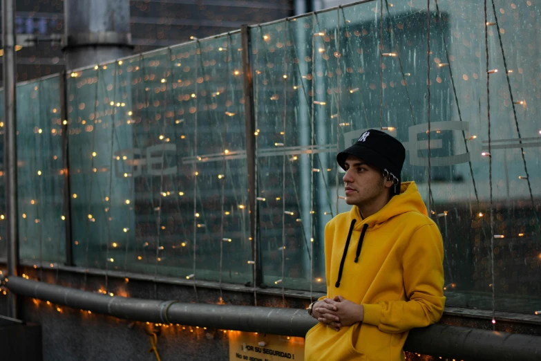 a man is standing near a fence with lights