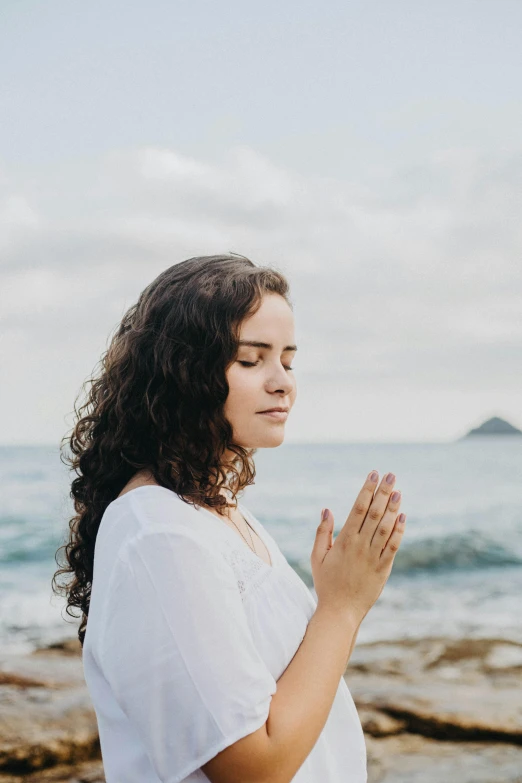 a woman sitting on the rocks looking off into the distance