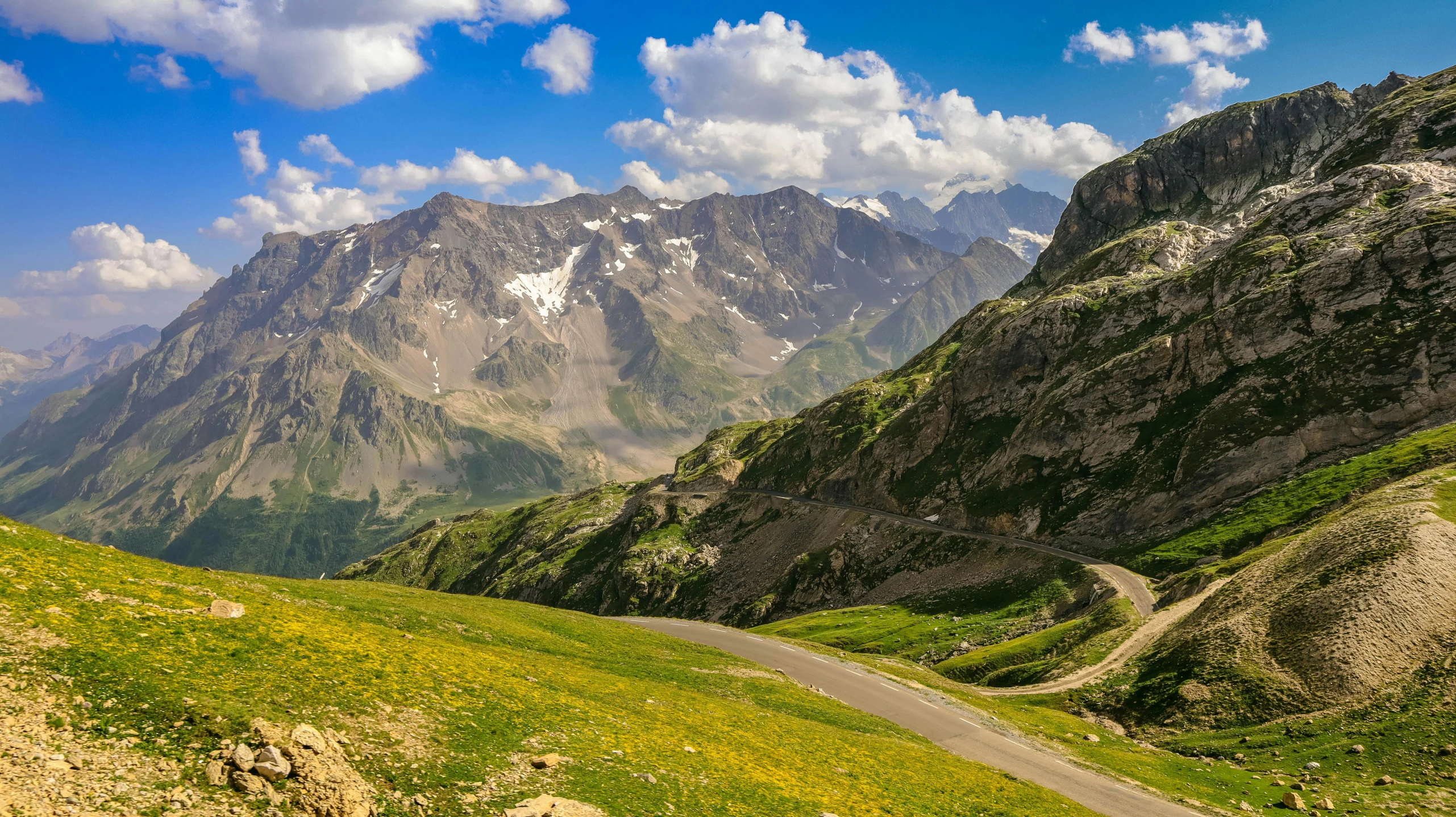 a scenic view of a mountain with road going uphill and towards the sky