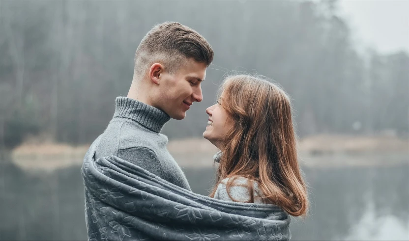 an image of couple wrapped up near water