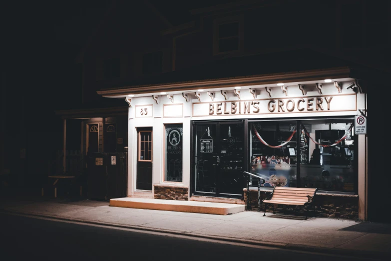 a bench sitting on a street sidewalk outside of a store