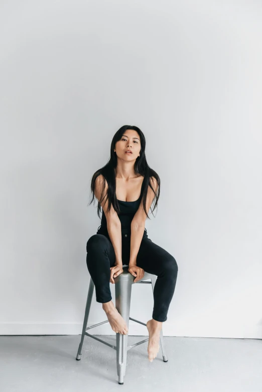 a woman is seated on a chair doing gymnastics