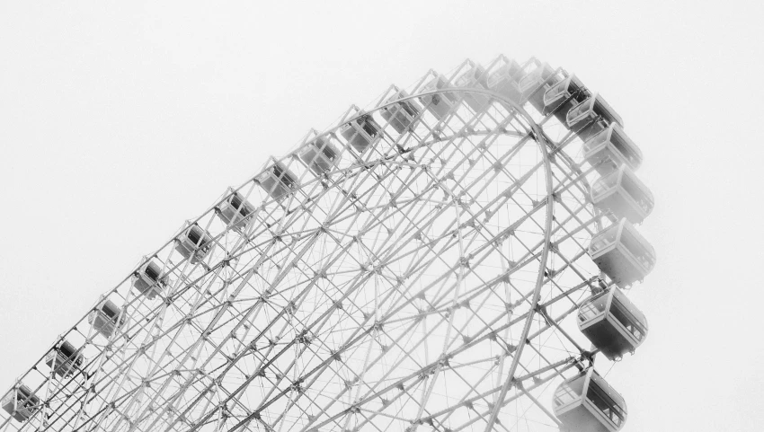 a large ferris wheel against a foggy sky