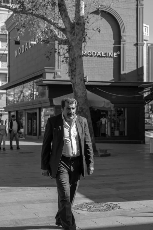 a man in a suit walks down the street