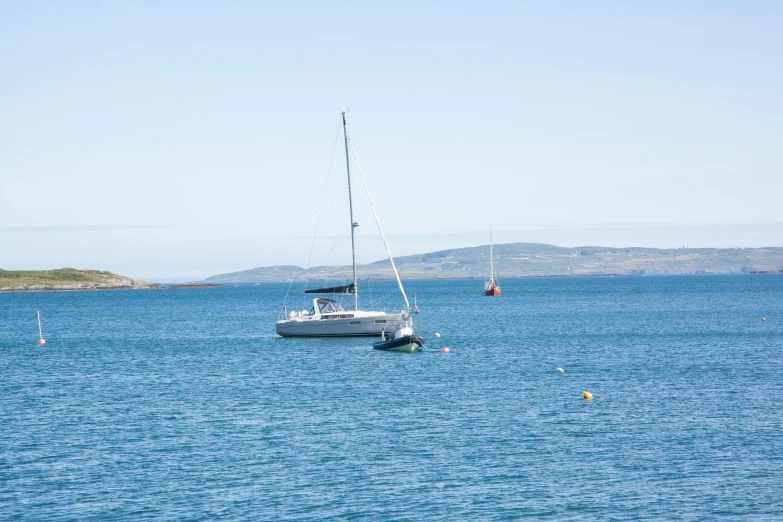 a boat floating on the water next to a shore line