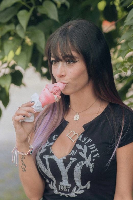 a girl is eating a donut and holding soing in her hands