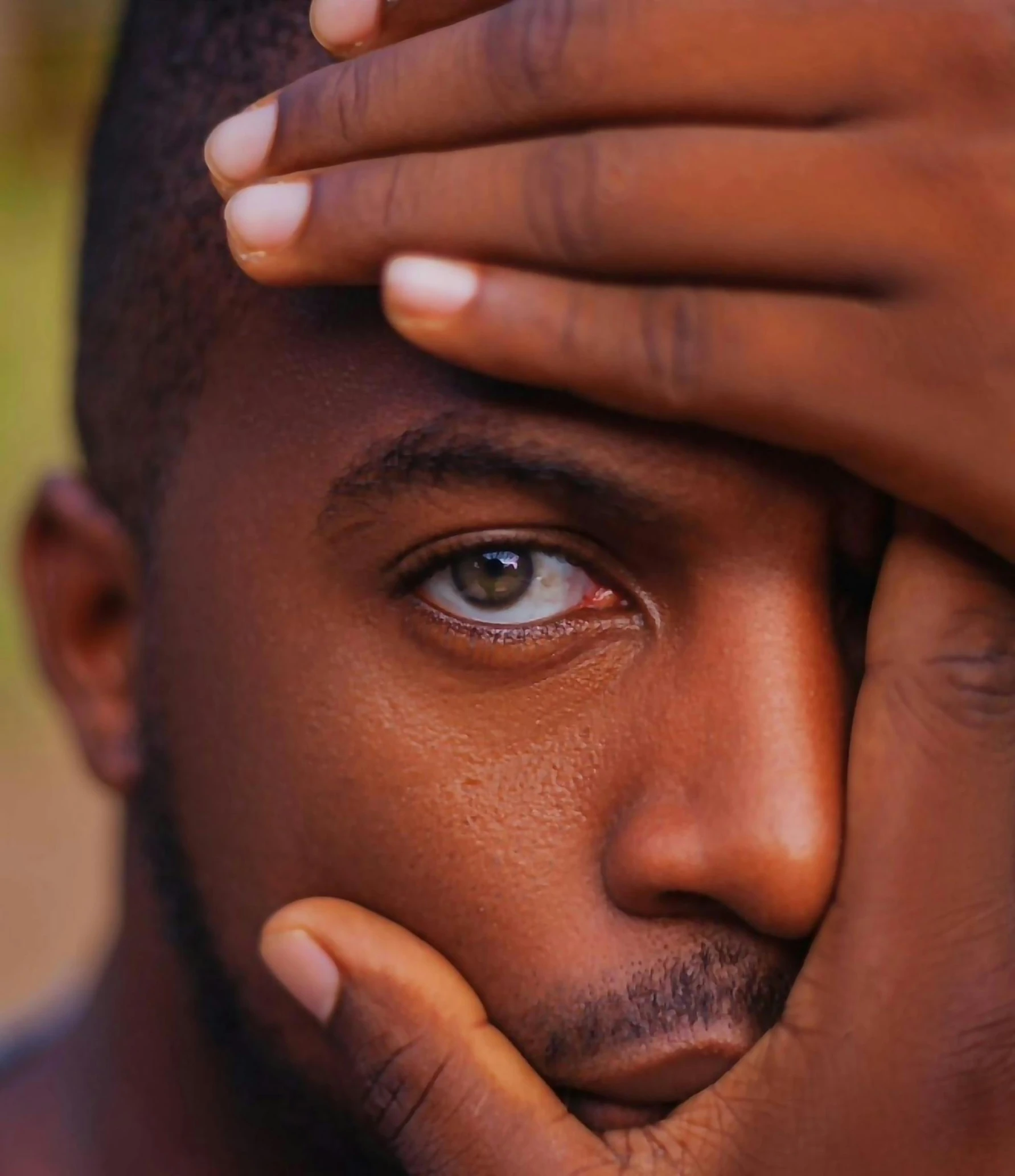 a young man is holding his chin to his face