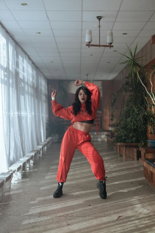 the woman is wearing red in her studio