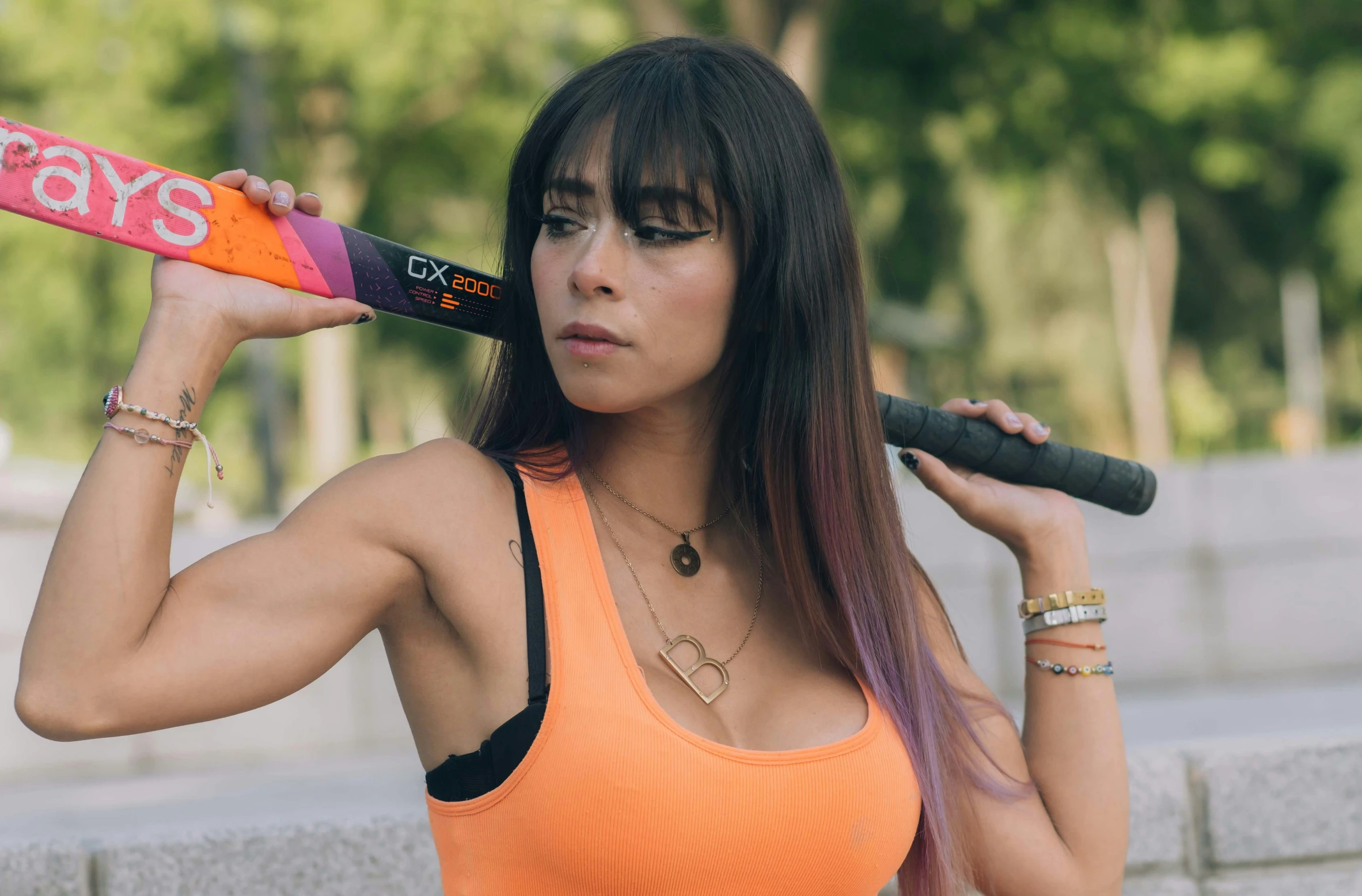 a woman holding a baseball bat and wearing a top