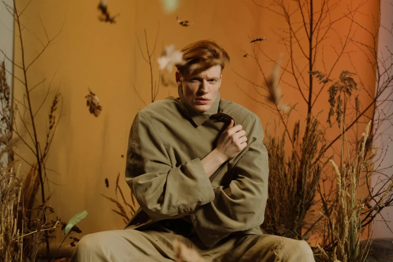 a man sits in a room surrounded by plants