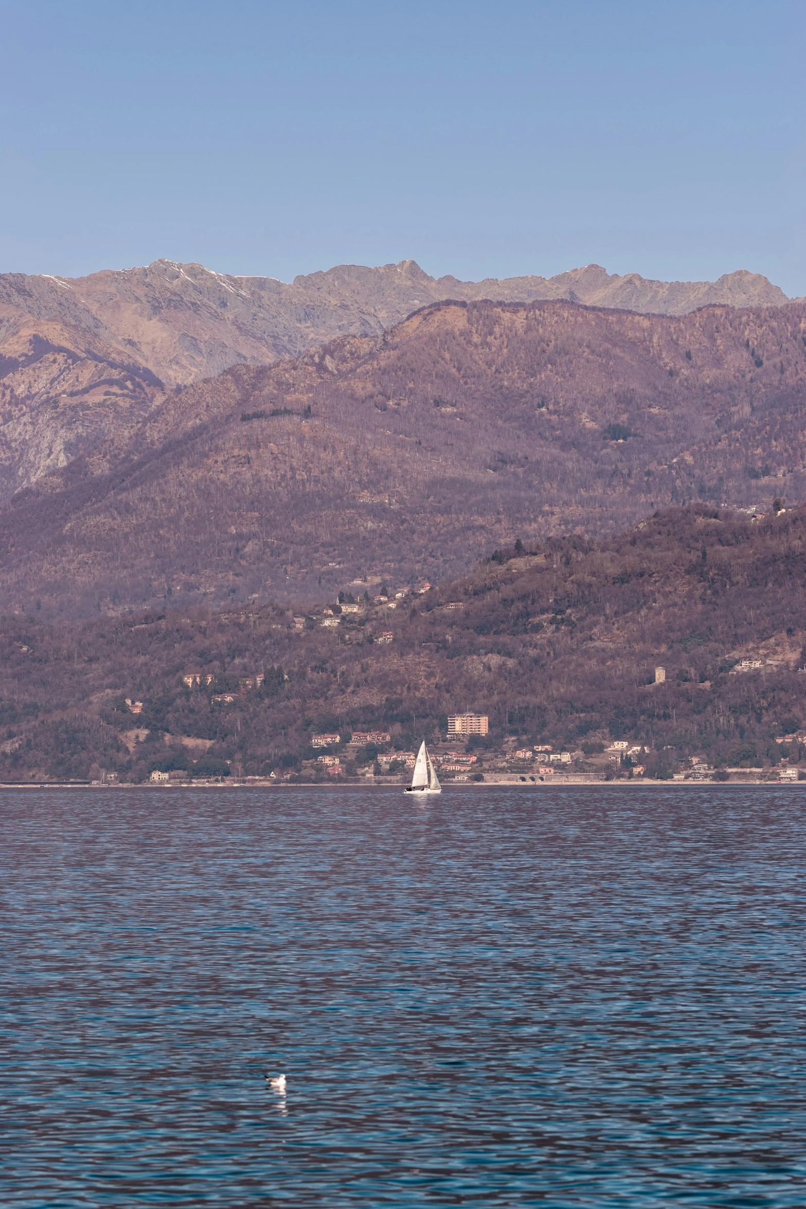 mountains and buildings are seen in the water