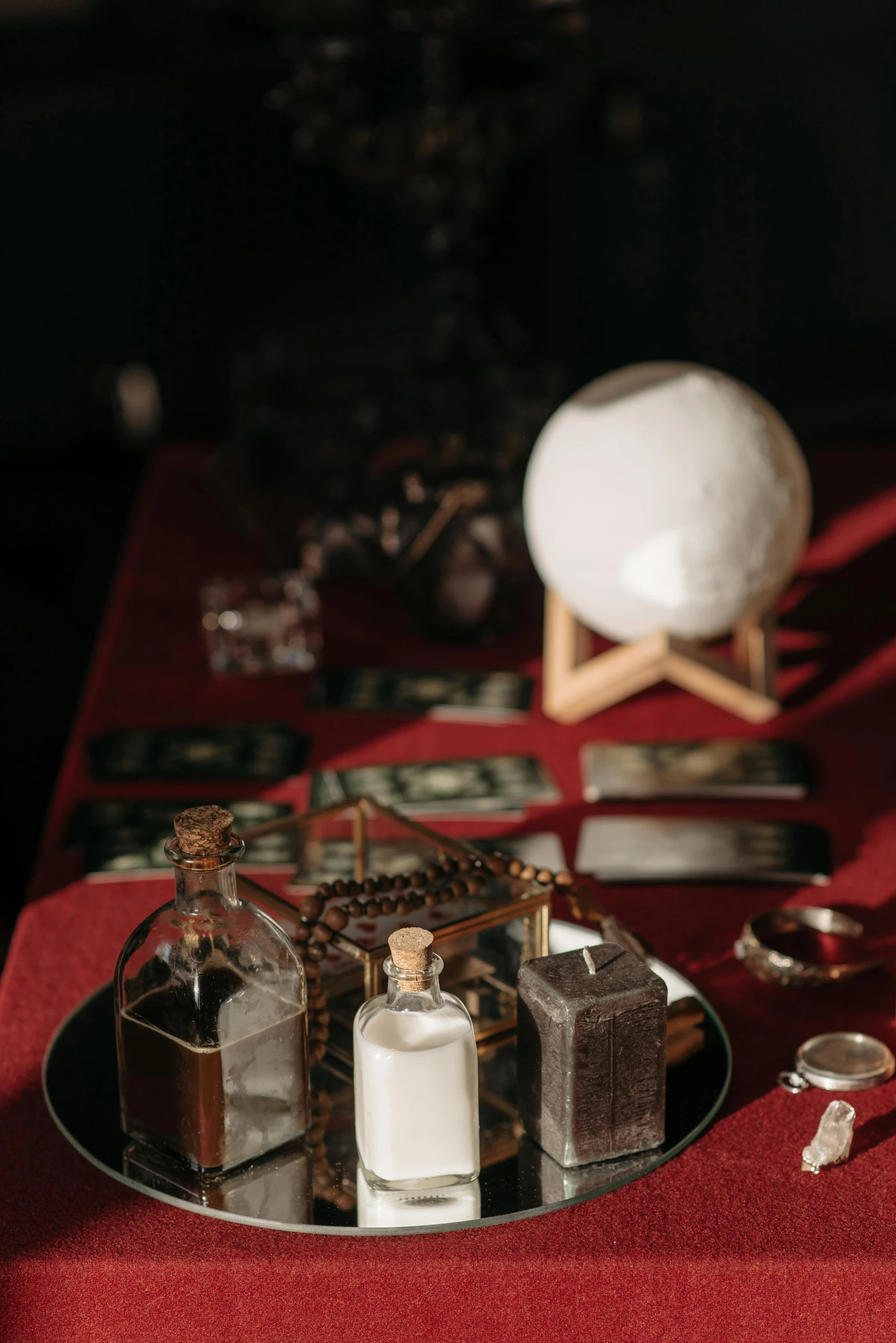 there is two bottles of perfume on a red table cloth