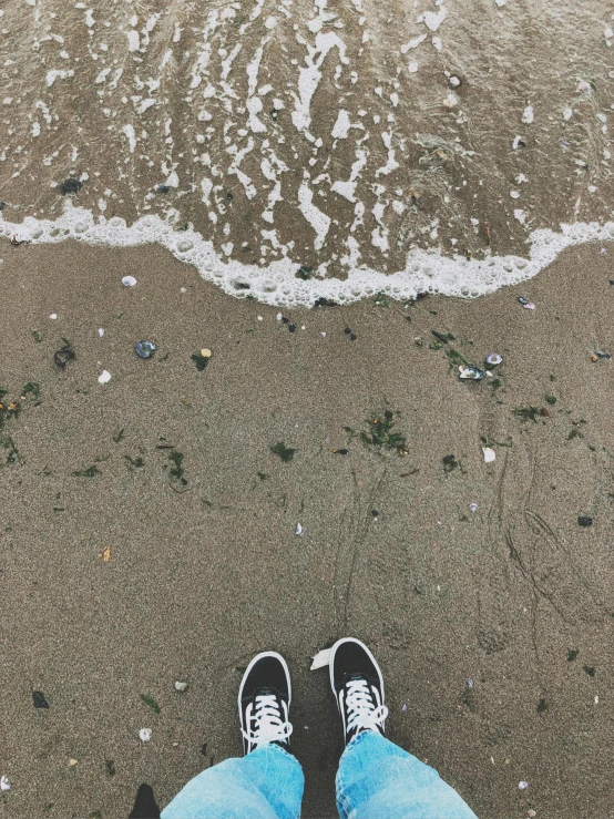 someone standing on the beach next to a wave