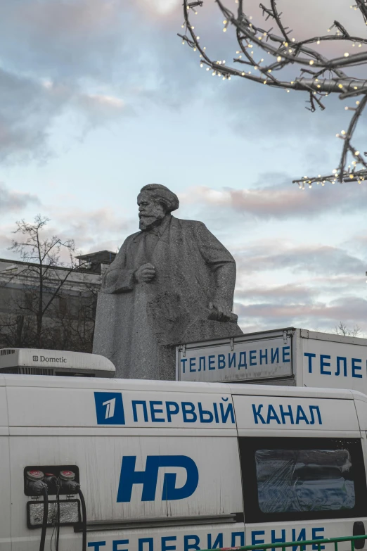 a bus with a statue in the back of it next to a building