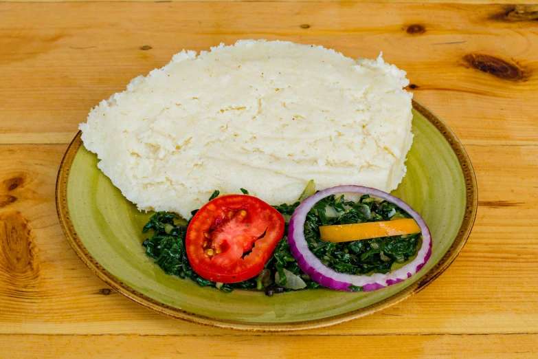rice, onions and green veggies sit on a green plate