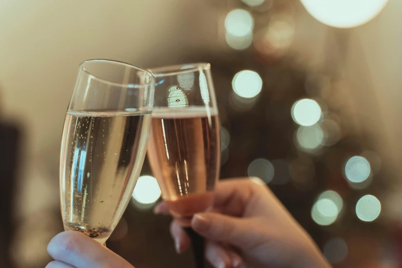 there is a pair of two champagne flutes being held by the hands