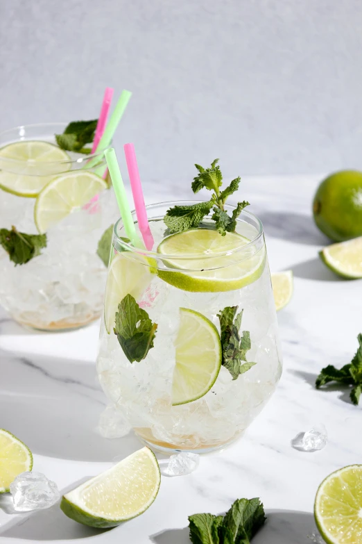 two glasses with limeade and mint on a marble table