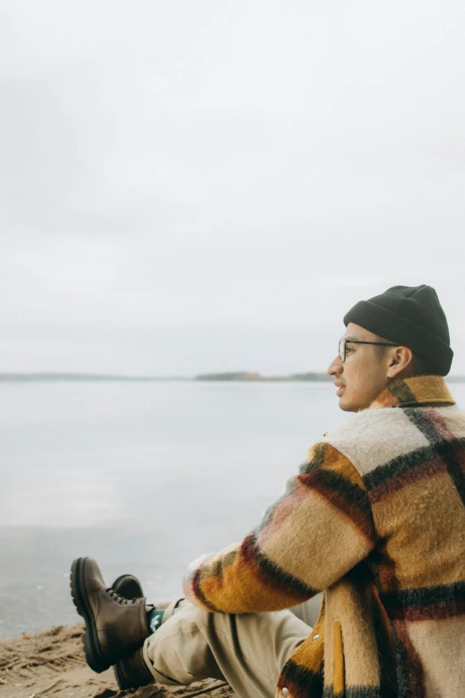 a man sitting on top of a sandy beach