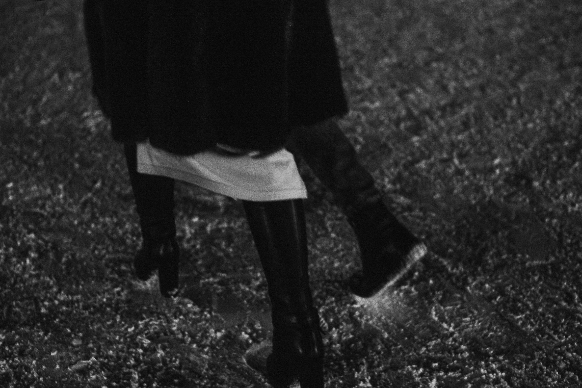 a black and white po shows a woman walking in grass with well dressed shoes