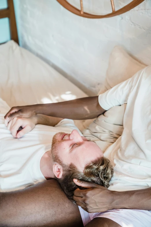 a man laying on top of a bed sleeping