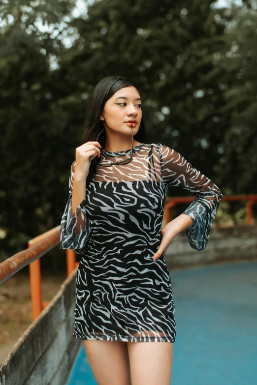 a girl standing near a railing posing for the camera