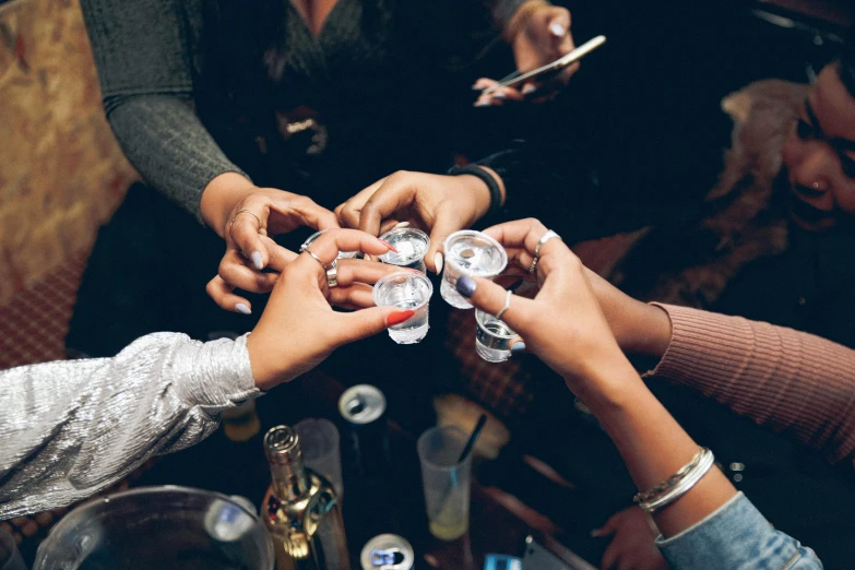 people in white are holding clear glass cups