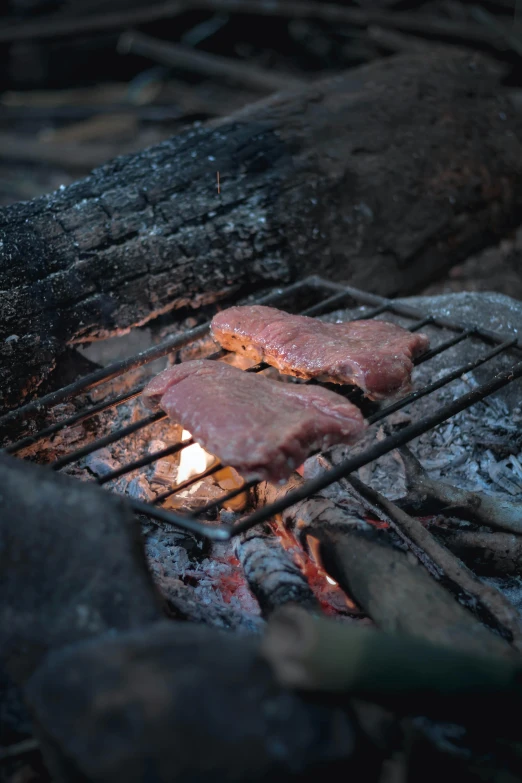 meat is cooking on the grill at night