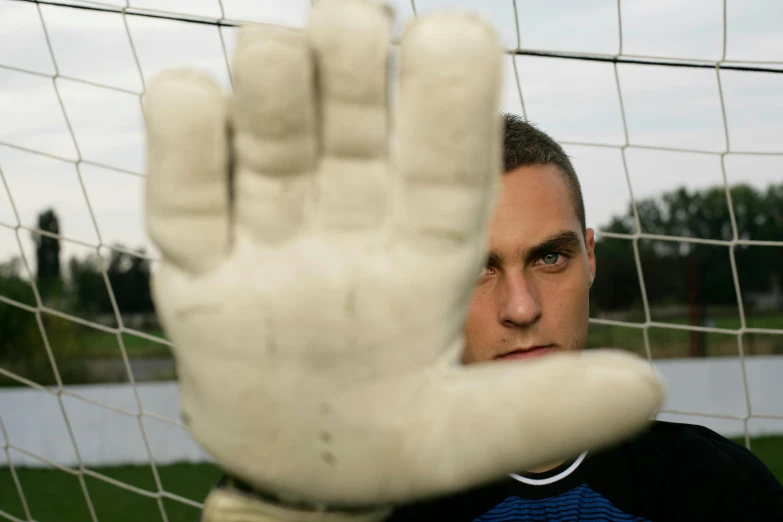 a man is seen holding up a ball in front of the net