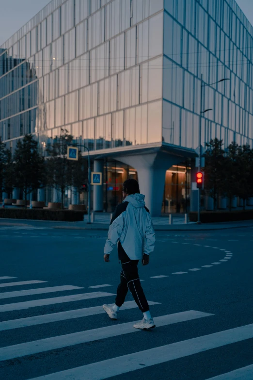 a woman crossing the street in front of a building