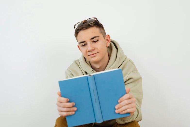 a guy reading a book looking up at the camera