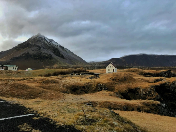 a lonely house near mountains on an overcast day