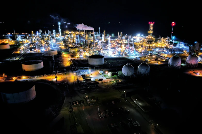 a night scene of an oil refinery, with all the lights on