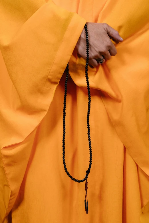 a man holding the cross with his hands on the chain