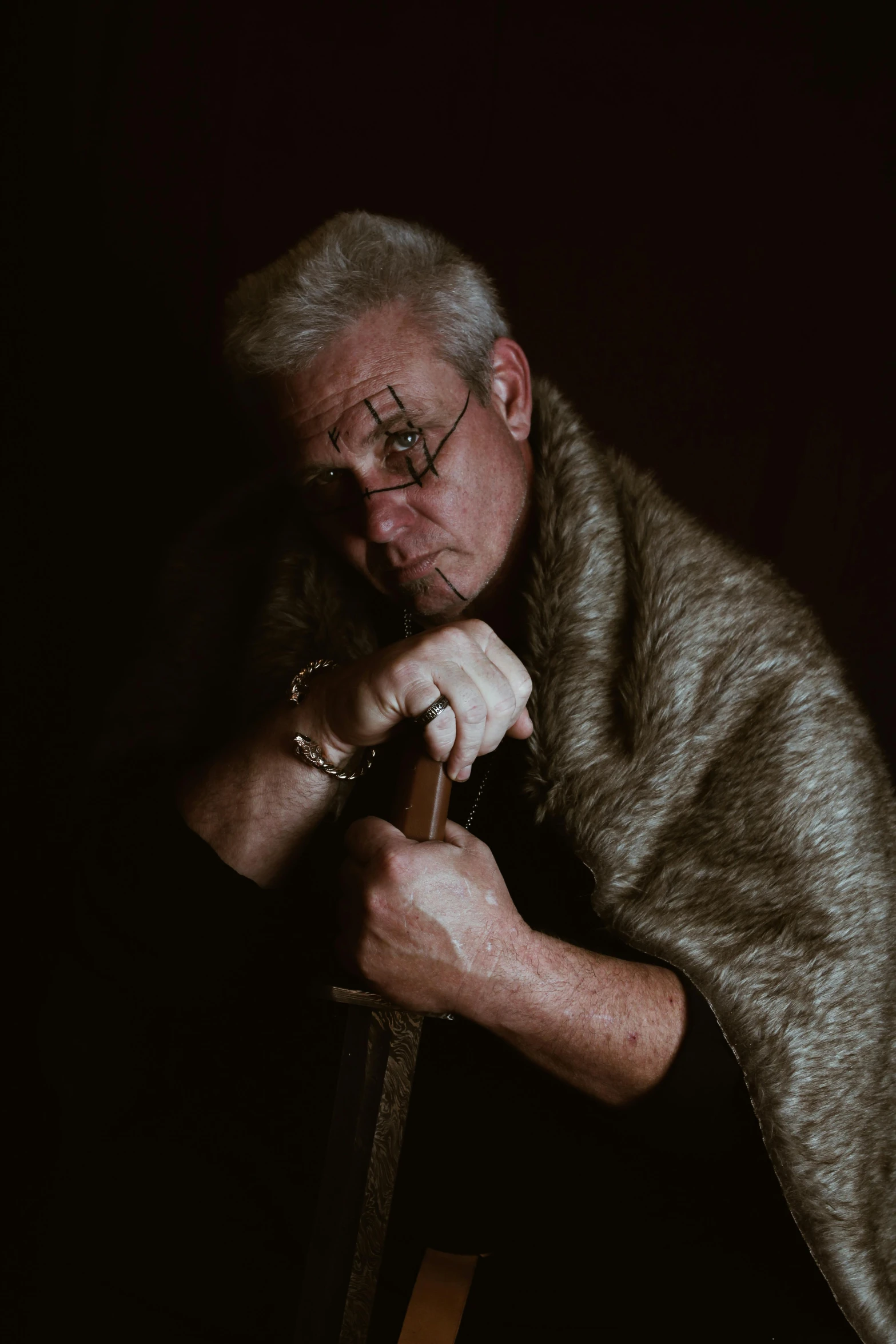 a man wearing a silver celet and wearing a fur jacket