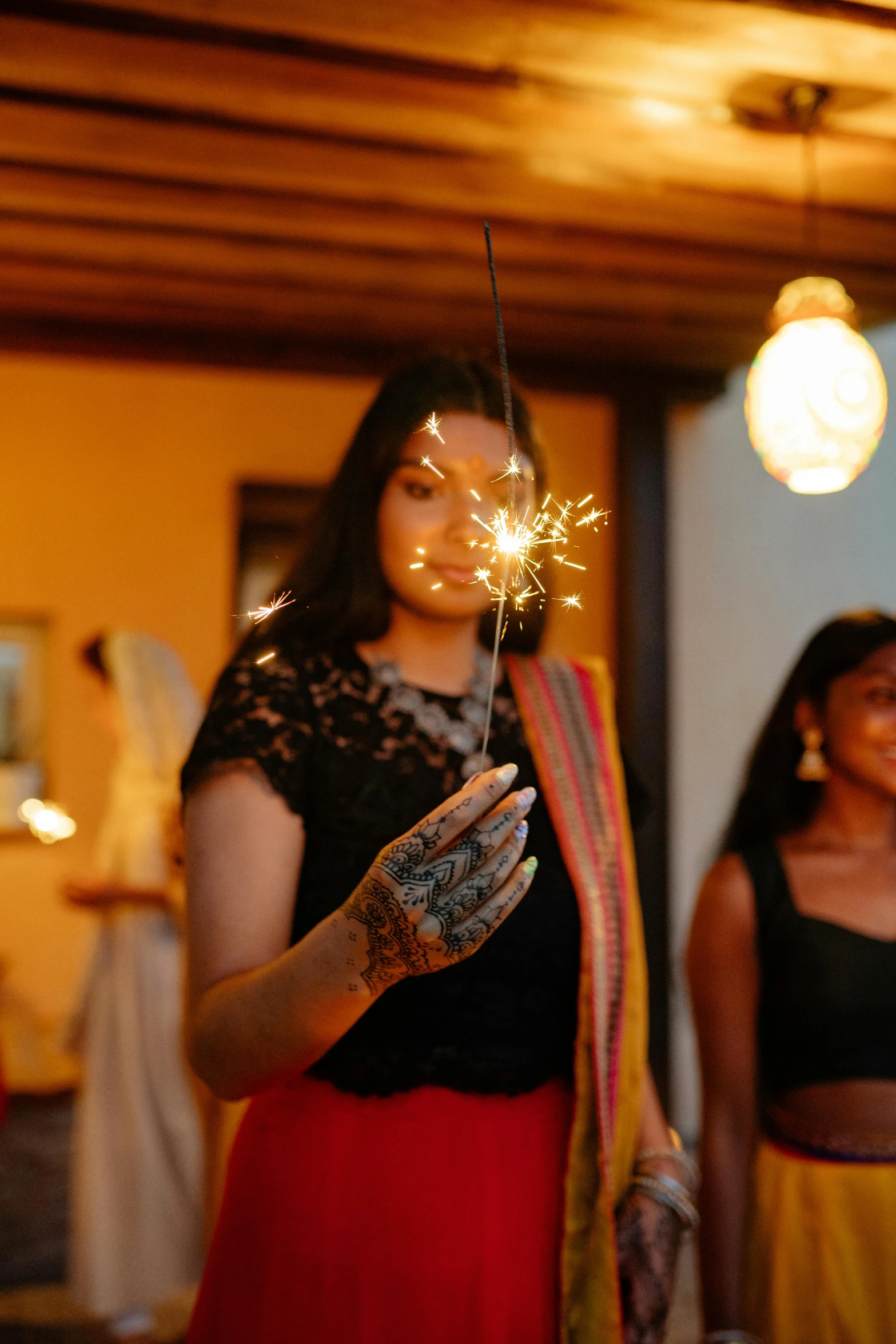 a woman with her hand on a sparkler that is on the ground