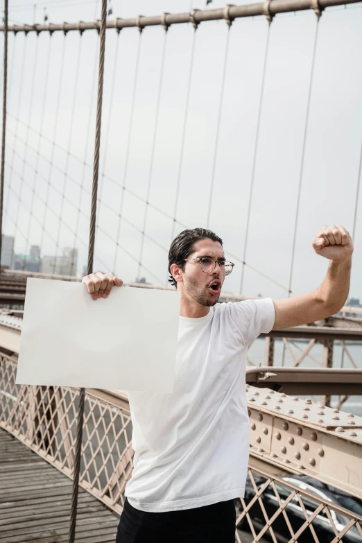 a man with a large banner on the brooklyn bridge