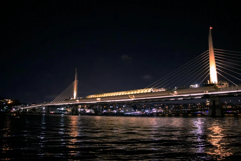 a bridge is lit up in the night by bright lights