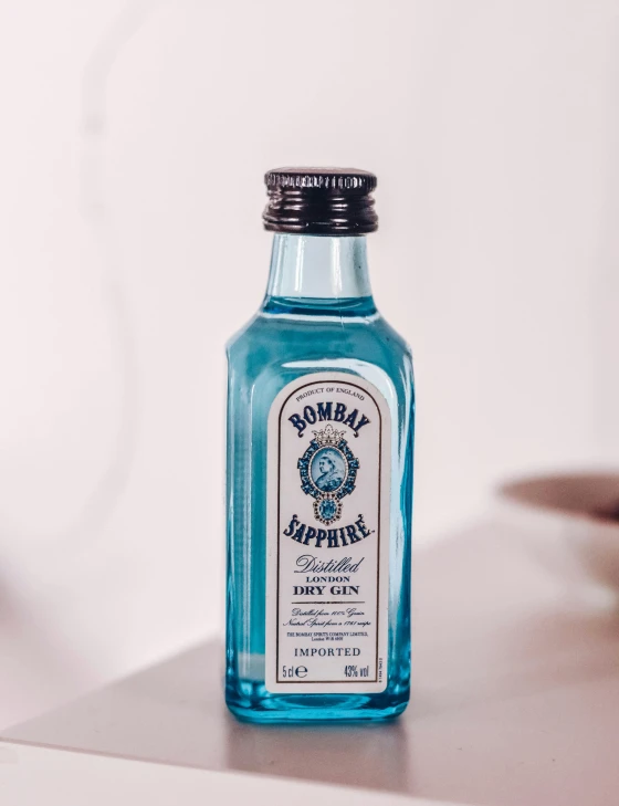 a bottle of blue ink sitting on top of a white table