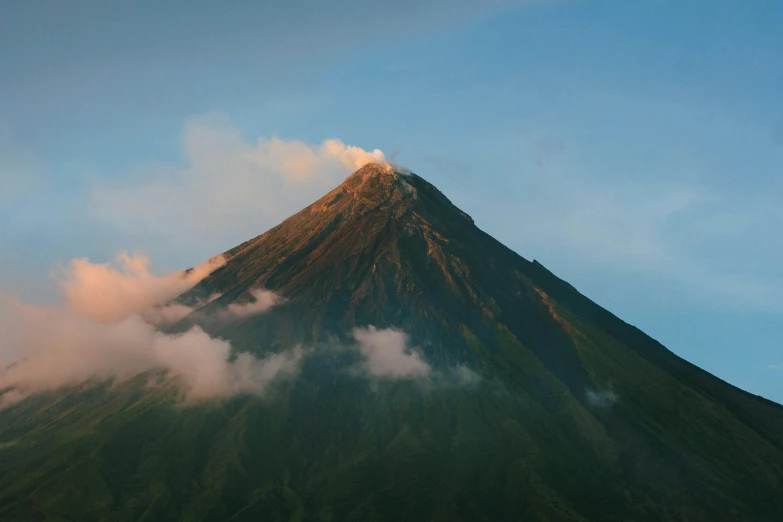 a big mountain with some clouds floating in it