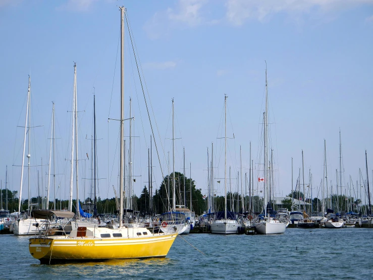 a sailboat floating in the water near many other boats