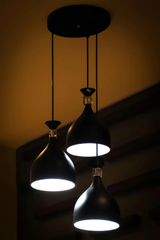 three large circular shaped lights hang from a ceiling