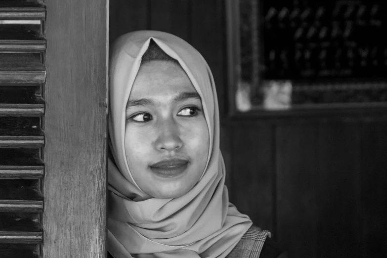 a woman with headscarves standing in front of a door