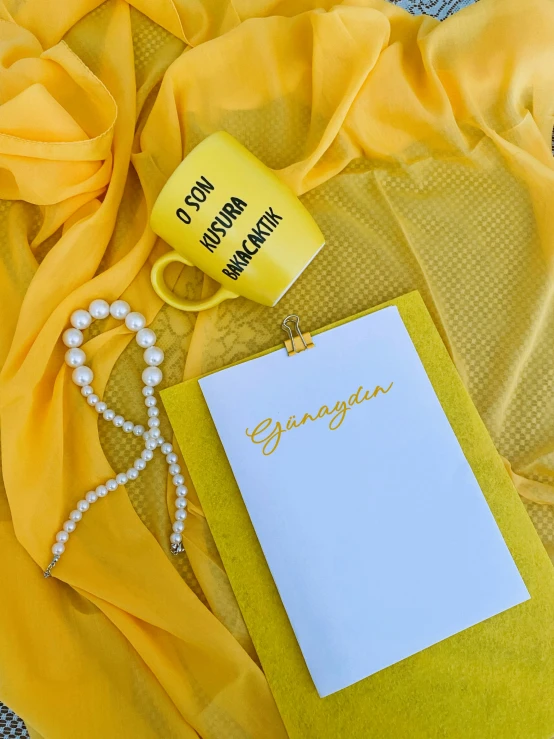 a table with yellow sheets and cards and a tassel