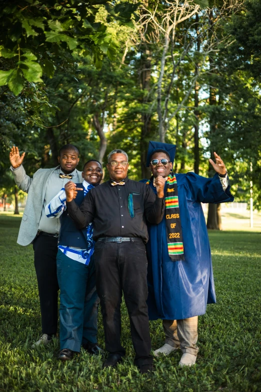 four adults stand smiling and posing for a po