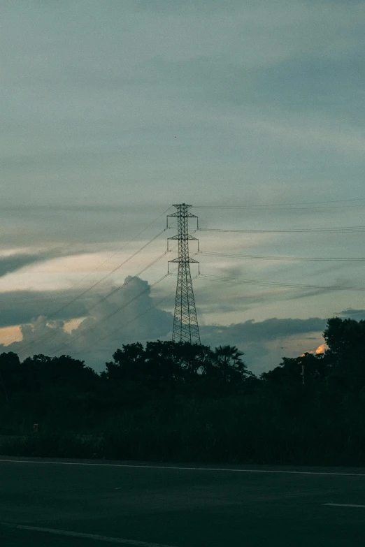 an old, abandoned radio tower rises in the air near trees